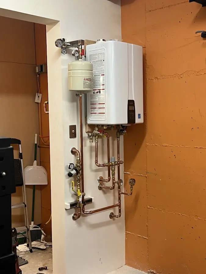 Plumbing technician inspecting water heater connections in Aiea
